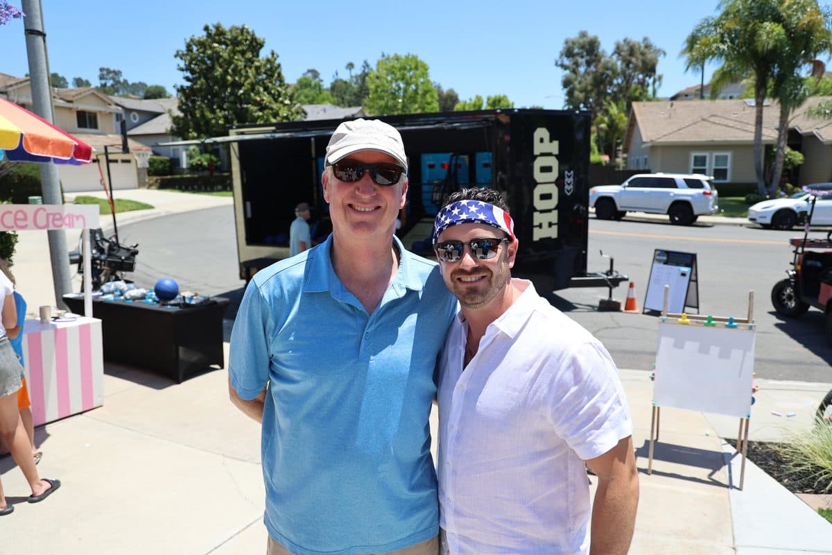The Hoop San Diego team in front of the arcade basketball trailer at an event