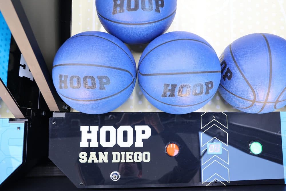 HOOP San Diego branded basketballs stacked inside the arcade trailer