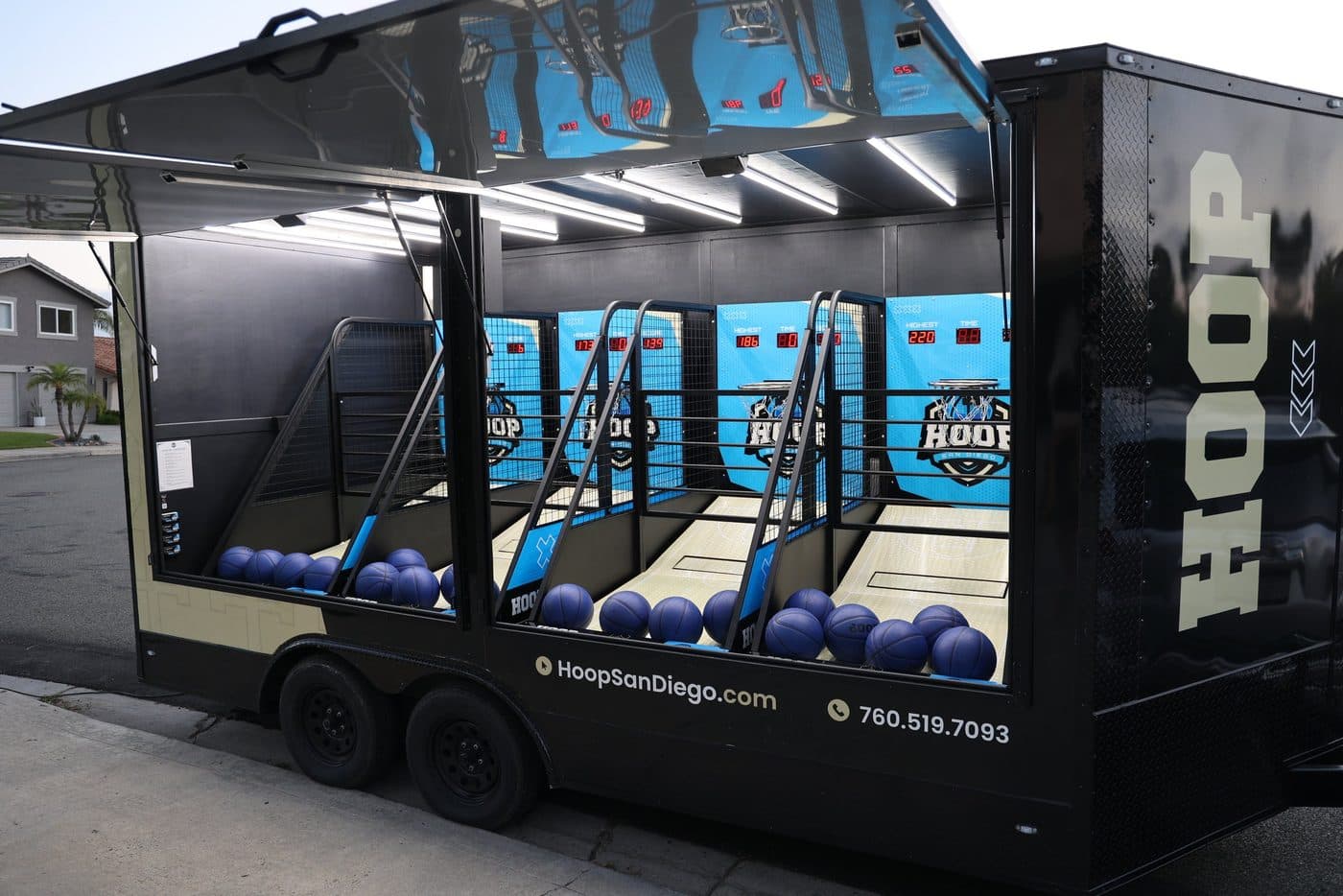 Side profile of the black Hoop San Diego trailer with cyan game panels